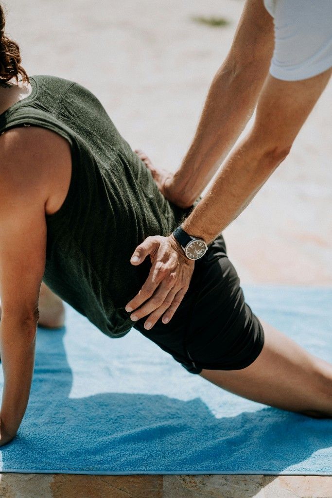 Une professionnelle accompagne une personne pendant un exercice en plein air.